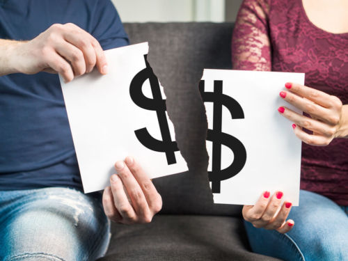 man and woman holding two halves of money symbol paper
