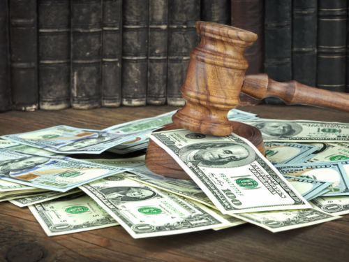 gavel on a table scattered with money