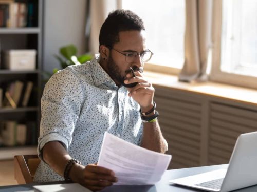 man focused on his computer and documents