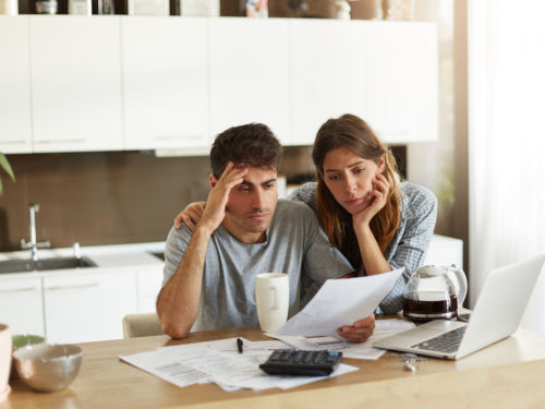 worried couple looking at bill