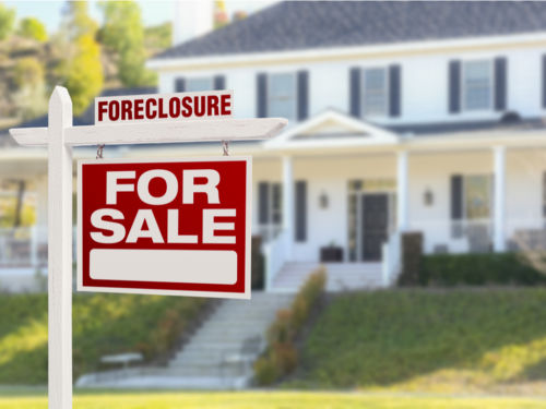 foreclosure for sale sign in front of house