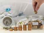 pennies in a jar labeled investment next to an alarm clock