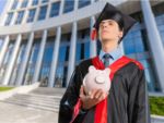 college graduate holding a piggy bank to pay student loans