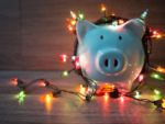 blue piggy bank wrapped in christmas lights